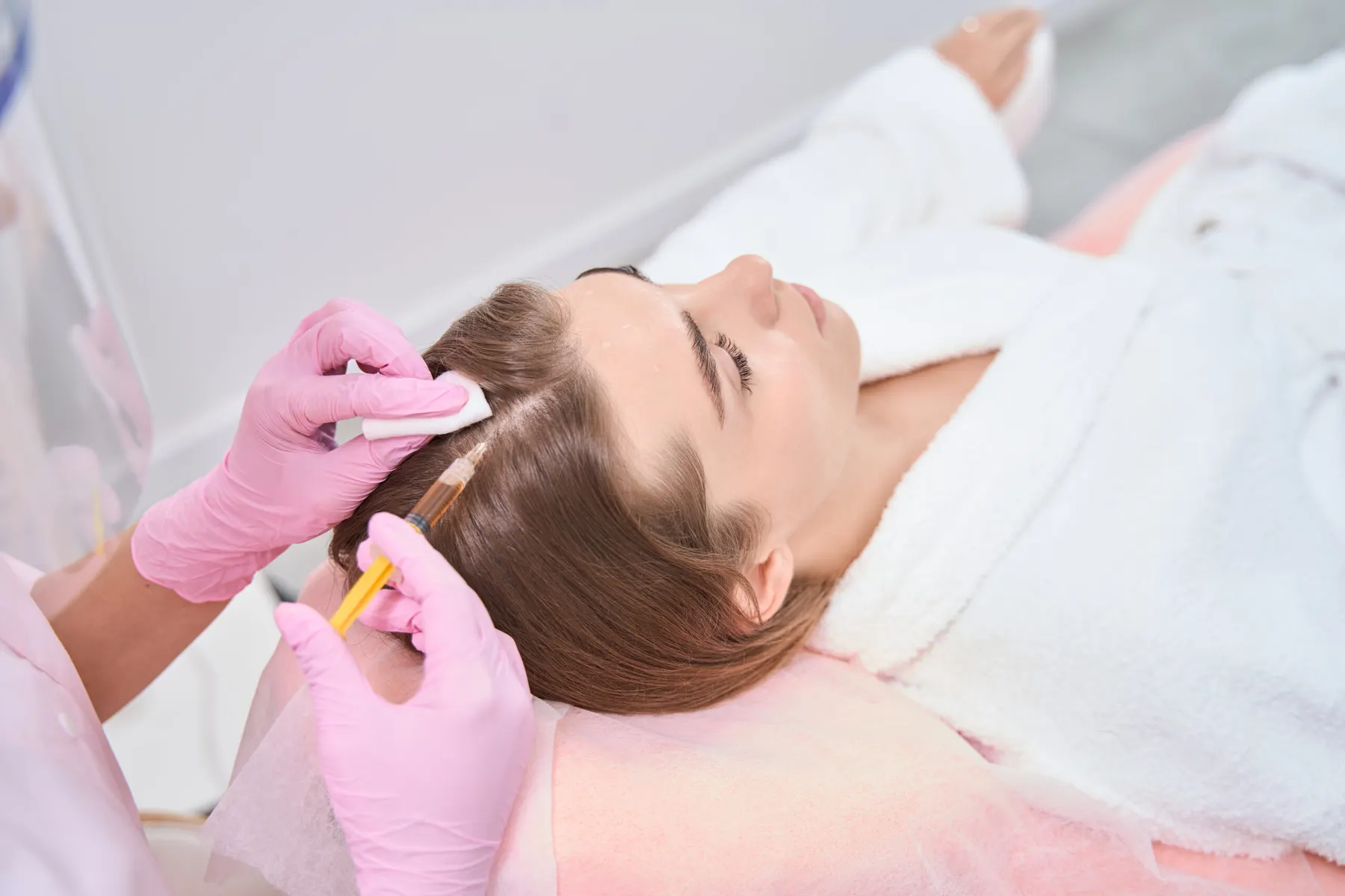 A clinician in sterile gloves performing a precise procedure on a client's skin
