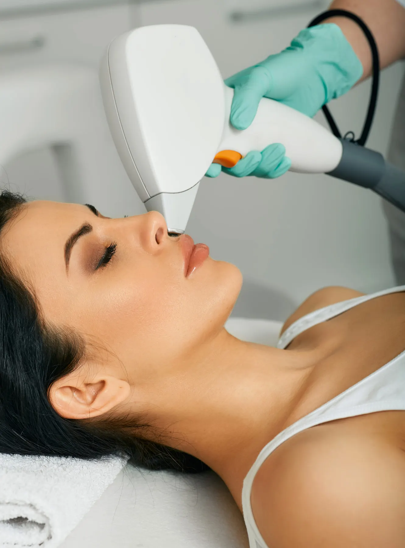 A client receiving a light-based facial treatment at the clinic wearing eye protection